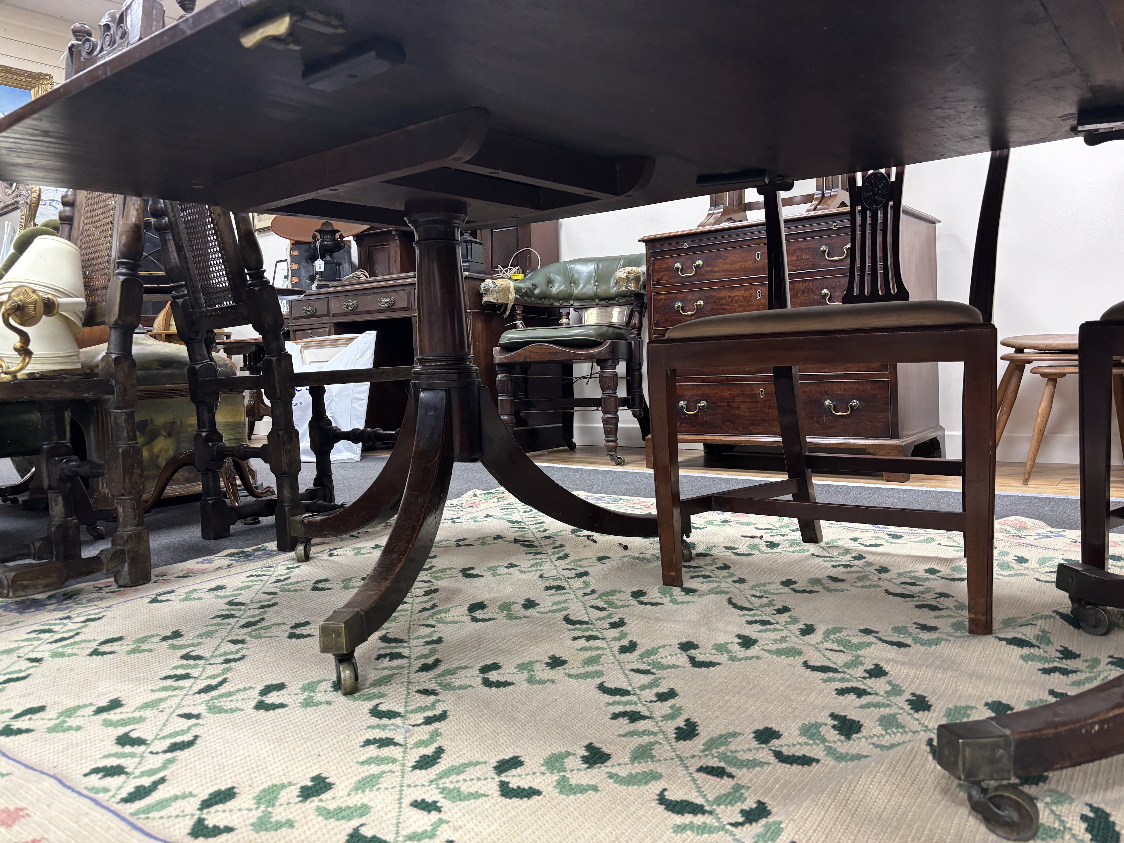 A George III style mahogany triple pillar extending dining table, 346cm extended, two spare leaves, depth 118cm, height 75cm